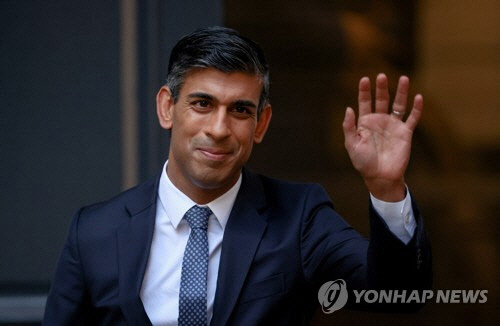 리시 수낵 영국 보수당 신임 대표 및 총리 내정자가 24일(현지시간) 보수당 당사 밖에서 손을 흔들고 있다.  런던=로이터 연합뉴스